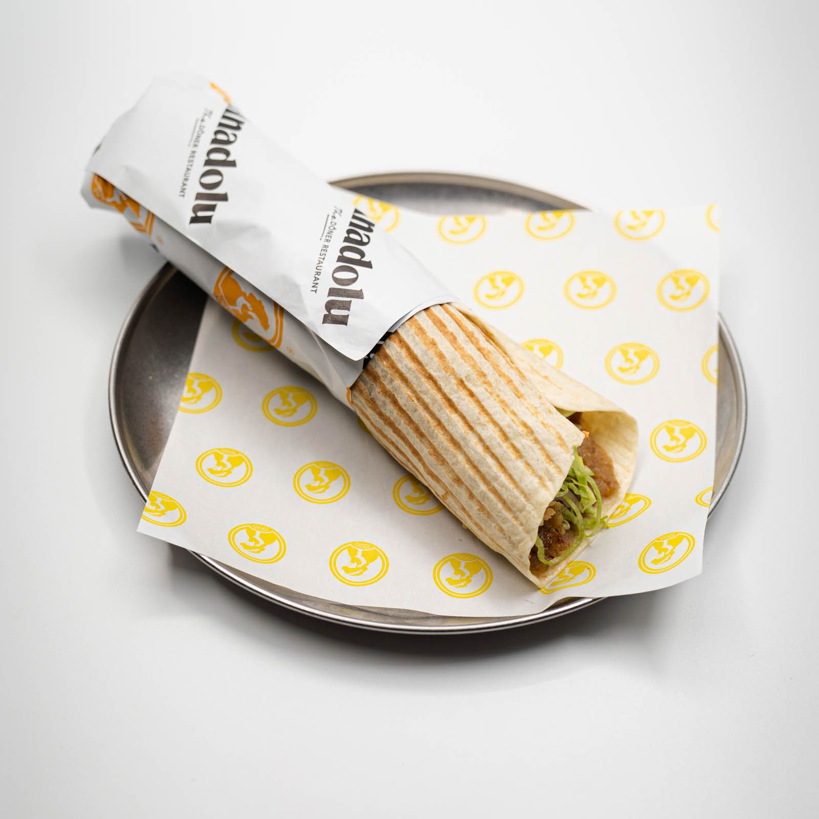 Ingepakte durum van Anadolu, gegrilde wrap in Anadolu-papier op een metalen bord